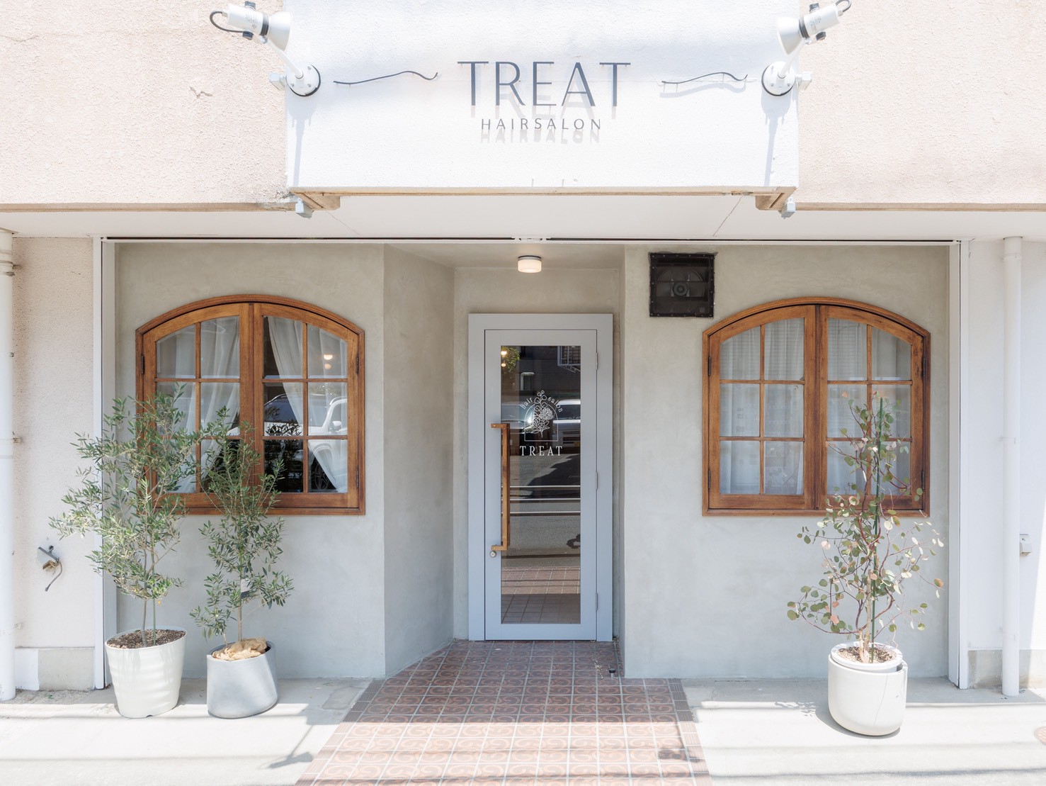 木枠の窓と植物が目印のTREAT外観